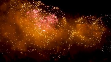 Soyut bir bulanıklık, gece gökyüzünde bokeh ışıkları ve gerçek altın parıldayan havai fişekler. Parlak havai fişek gösterisi. Yeni yıl kutlamaları havai fişeklerle yapılır.