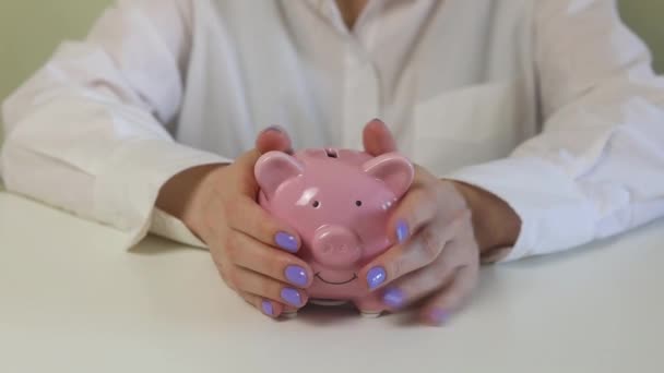 Närbild Kvinnliga Händer Sätter Mynt Rosa Spargris Bank Ett Träbord — Stockvideo