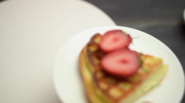 Çilekli Belçika waffleları ve ahşap, koyu bir masada kahve. Lezzetli kahvaltı konsepti.