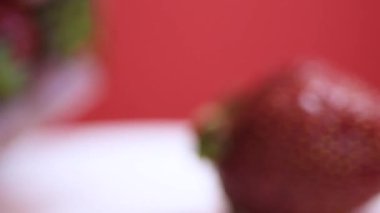 Taze olgun yabani çilek yığını dönüyor. Yaz çileği hasadı yakın plan bir tabakta. Çilekler dönüyor. Faydalı yabanmersini. seçici odak