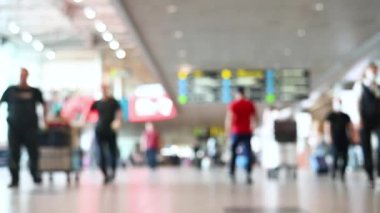 Bulanık görüntü, havaalanı seyahat konseptinde yürüyen bavullu turistler.