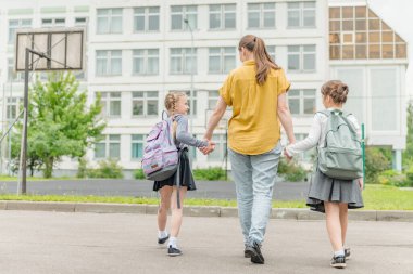 Annesiyle mutlu iki kız okul eğitimine gidiyor.