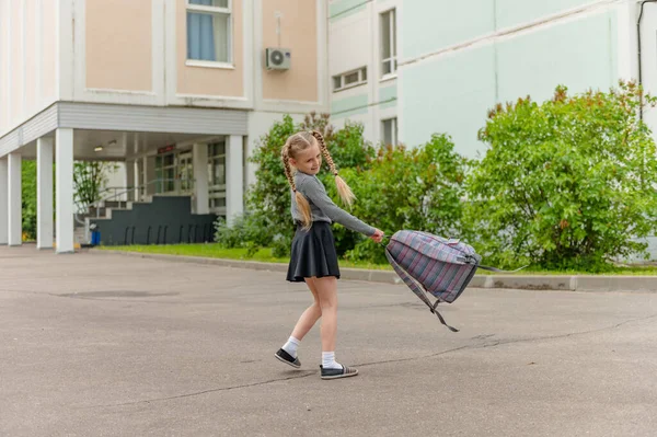 Carino ragazze felici studentesse con zaini stanno giocando vicino alla scuola — Foto Stock