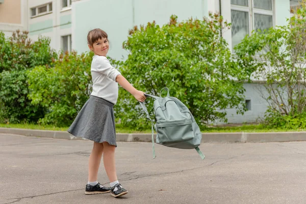 Bonito menina feliz alunas com mochilas estão jogando perto da escola — Fotografia de Stock