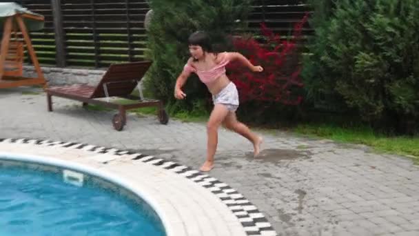Menina criança nada na piscina azul no verão — Vídeo de Stock