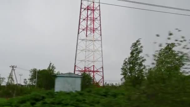 The view from the car window in the village on the green trees the pillars of the house in the daytime in the rain and the gray sky lightning strike — Stock Video