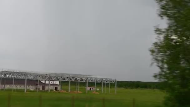 Вид из окна автомобиля в деревне на зеленых деревьях столбы дома в дневное время под дождем и серое небо молния удар — стоковое видео