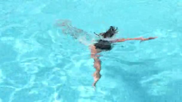 Дівчинка дитина плаває в блакитному басейні влітку — стокове відео
