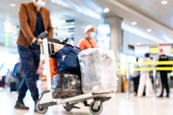 Imagen borrosa personas en máscaras médicas caminando con maletas maletas maletas en el concepto de viaje del aeropuerto — Foto de Stock