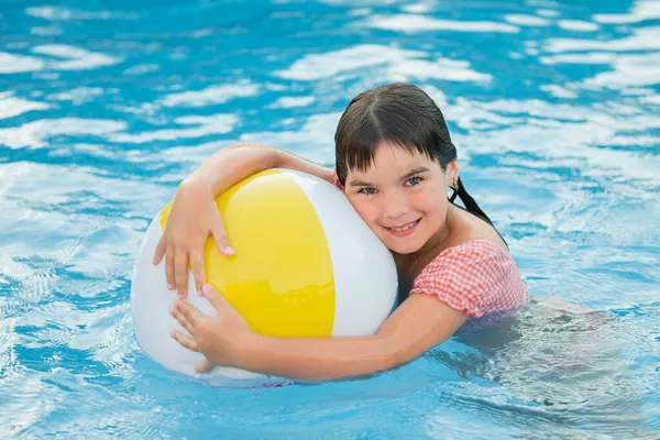Słodkie uśmiechnięta dziewczyna w jasny krąg pływa na tle niebieski basen w lecie Obraz Stockowy