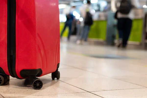 Люди в медичних масках, що ходять з багажними сумками валізи в концепції подорожей аеропорту — стокове фото