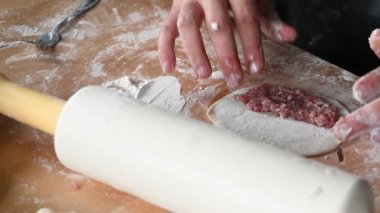 Evdeki mutfakta bir adam masayı hazırlar, hamur işini yapar, kıyma ev yemeği konseptini koyar.