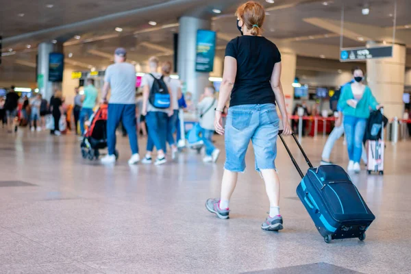 Osoby noszące maski medyczne spacerujące z walizkami bagażowymi na lotnisku koncepcji podróży Obrazy Stockowe bez tantiem