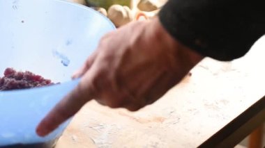 Evdeki mutfakta bir adam masayı hazırlar, hamur işini yapar, kıyma ev yemeği konseptini koyar.
