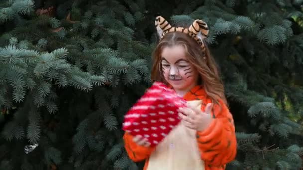 Mignonne fille heureuse dansant et souriant en costume de tigre avec concept cadeau de l'année du tigre 2022 — Video