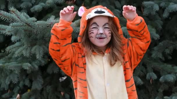 Милая счастливая девушка танцует и улыбается в костюме тигра с подарочной концепцией года тигра 2022 — стоковое видео