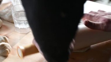 Evdeki mutfakta bir adam masayı hazırlar, hamur işini yapar, kıyma ev yemeği konseptini koyar.