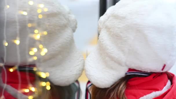 Повільний рух.маленька дівчинка дивиться на вікно з новорічними вогнями, усміхненою, різдвяною концепцією — стокове відео