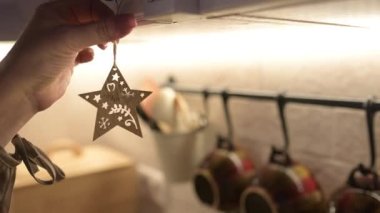 Kız evin Noel süslerine parmaklarıyla dokunur, Noel tatili için evi dekore eder.