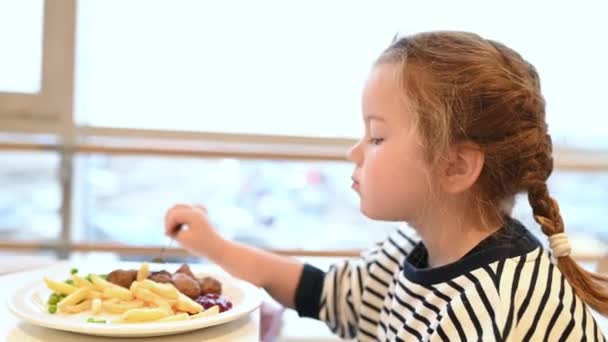 Lány, gyerek eszik sült krumplit, gyorsétterem egy bevásárlóközpontban — Stock videók