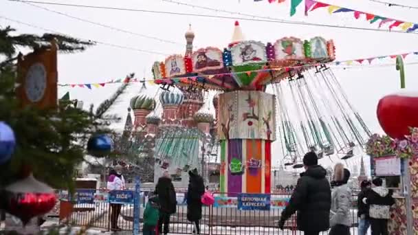 09, 12, 2021 09, 12, 2021 러시아 사람들은 크리스마스 시장 과 겨울의 회전목마를 배경으로 붉은 광장을 걷는다 — 비디오