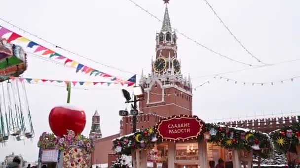 09,12,2021 09,12,2021 Rusland Moskou Mensen lopen op het Rode Plein tegen de achtergrond van de kerstmarkt en de draaimolen in de winter — Stockvideo