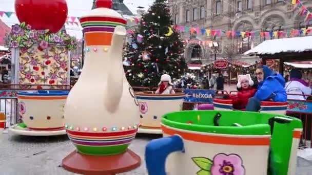 09,12,2021 Rusland Moskou Mensen lopen op het Rode Plein tegen de achtergrond van de kerstmarkt en de draaimolen in de winter — Stockvideo