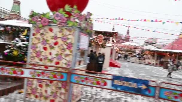09,12,2021 09,12,2021 Rusland Moskou Mensen lopen op het Rode Plein tegen de achtergrond van de kerstmarkt en de draaimolen in de winter — Stockvideo