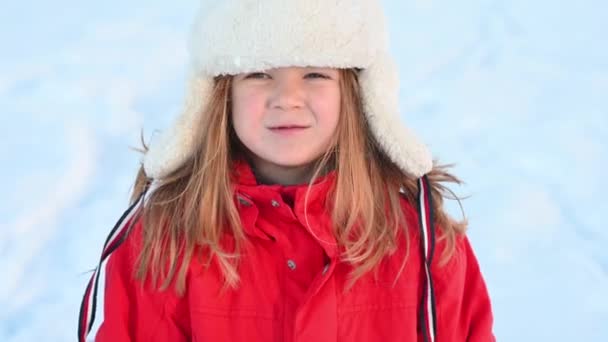 冬天，身穿红色夹克、头戴充气管子的小女孩在雪地里滑行 — 图库视频影像