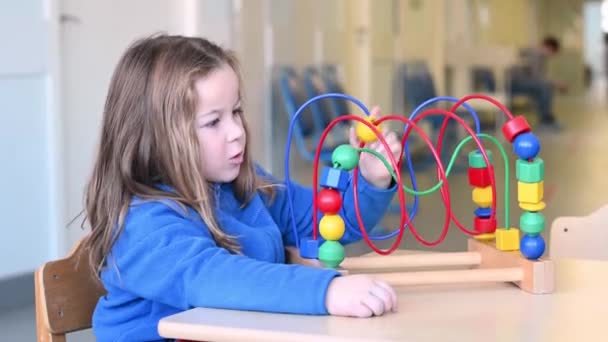 Niña divertida jugando en la clínica esperando una cita con el médico — Vídeos de Stock