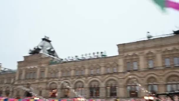 09,12,2021 09,12,2021 Rusland Moskou Mensen lopen op het Rode Plein tegen de achtergrond van de kerstmarkt en de draaimolen in de winter — Stockvideo