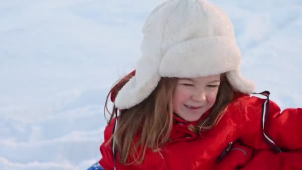 Ritratto di una bambina che ride all'aperto su uno sfondo di neve in inverno primo piano — Video Stock