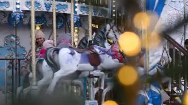 16,12,2021 Rusya 'lı Moskova' lı çocuk, kışın Noel atlıkarıncasında yeni yıl dekor ve ışıklarına karşı neşeyle yolculuk ediyor..