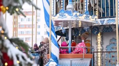 16,12,2021 Rusya 'lı Moskova' lı çocuk, kışın Noel atlıkarıncasında yeni yıl dekor ve ışıklarına karşı neşeyle yolculuk ediyor..