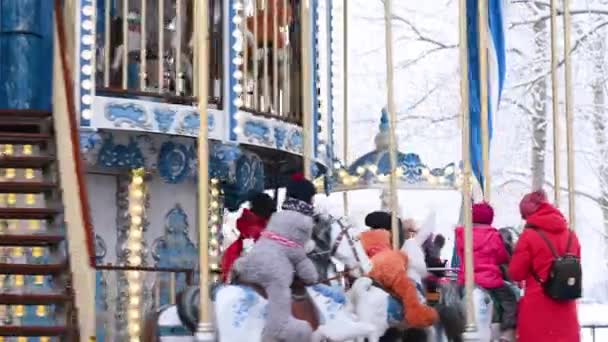 16.12.2021 Rusland Moskouse kinderen rijden in de winter vrolijk op de kerstdraaimolen tegen de achtergrond van nieuwjaarsdecor en -verlichting. — Stockvideo