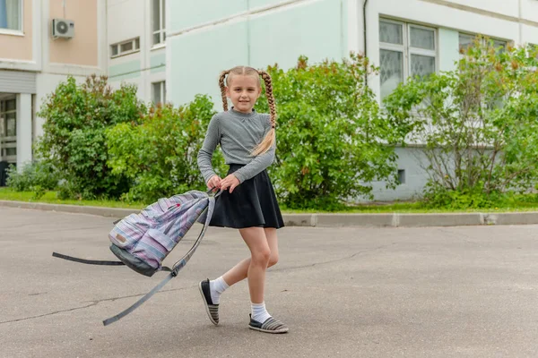 Linda chica feliz colegialas con mochilas están jugando cerca de la escuela —  Fotos de Stock