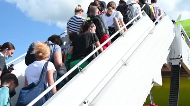 10,09,2021ロシア、モスクワ、ドモデドヴォ空港の人々は、会社S7の緑の飛行機に乗ってはしごを登る — ストック動画