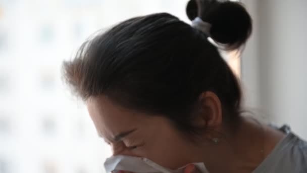 Vrouw ziek hoesten wrijven haar neus met een tissue — Stockvideo