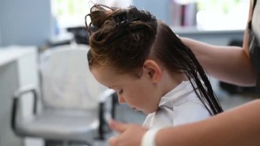 Bir güzellik salonunda saçını kestirirken çok tatlı bir kız.