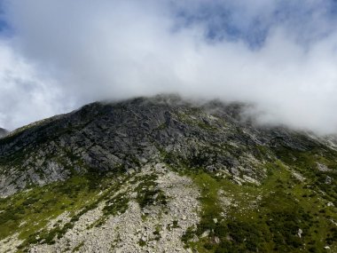 Bulut ve sis yazın yüksek dağ zirvesinin üzerinden geçiyor - St. Gotthard geçidi, San Gottardo İsviçre