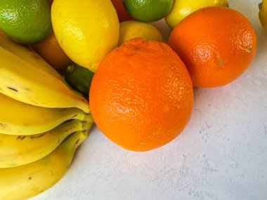 Beyaz taştan arka planda muzlu turunçgil meyveleri, yakın plan, boşluğu kopyala