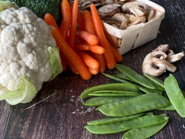 Taze karnabahar, bezelye, mantar, havuç ve brokoli içeren sebze çeşitleri.