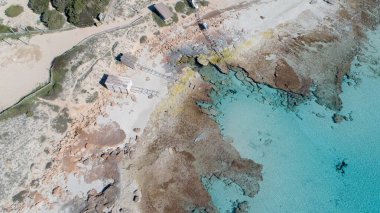 Geleneksel ahşap balıkçı kulübeleriyle inanılmaz turkuaz deniz ve kayalar. Hepsi bir İHA 'dan görünüyor..