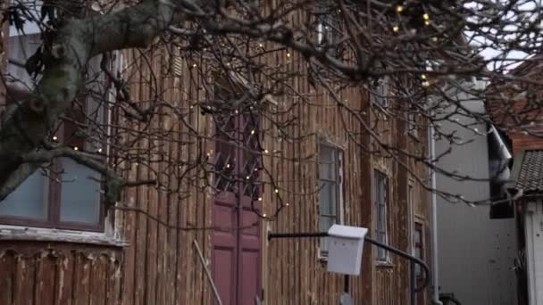 Gezellig houten huis exterieur met buiten Zitplaats in steegje, Tilt — Stockvideo