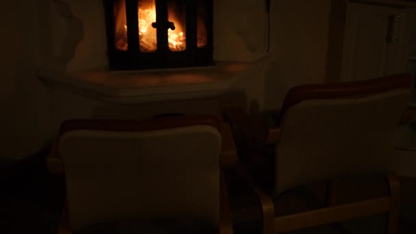 Due sedie vuote davanti al camino in mattoni con candele, accogliente e romantico — Video Stock