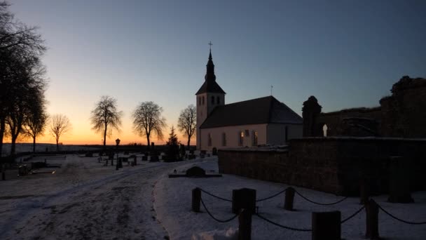 Kerk en begraafplaats zonsondergang met Copyspace tijdens de winter, handheld brede pan — Stockvideo
