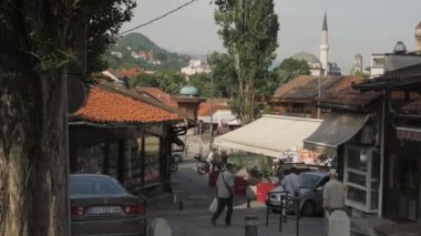 Saraybosna, Bosna - 18 Haziran 2022: Bascarsija 'da yayalar ve Araba Trafiği. Yüksek kalite 4k görüntü