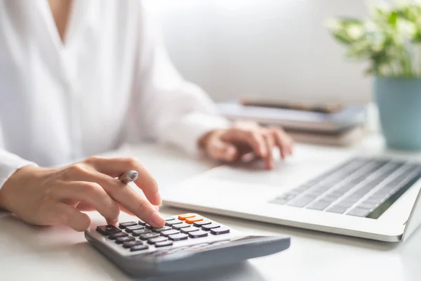 Kadın girişimci hesap makinesi kullanıyor, para biriktiriyor ve ofis konseptinde finansal harcamaları hesaplıyor..