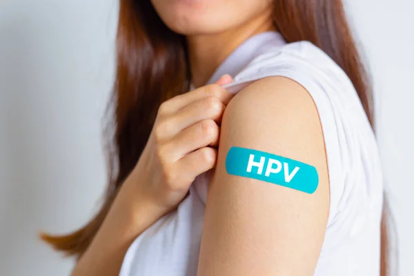 HPV (insan Papillomavirus) HPV aşısı olduktan sonra mavi bandaj gösteren genç bir kadın. Virüsler bazı türler genital bölgeleri enfekte eder ve rahim ağzı kanserine neden olabilir. Kadın sağlığı kavramı. 
