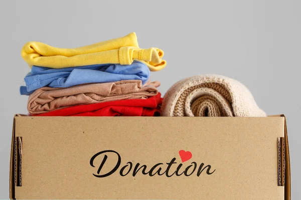 Box of clothes for donations. Clothing donation concept.